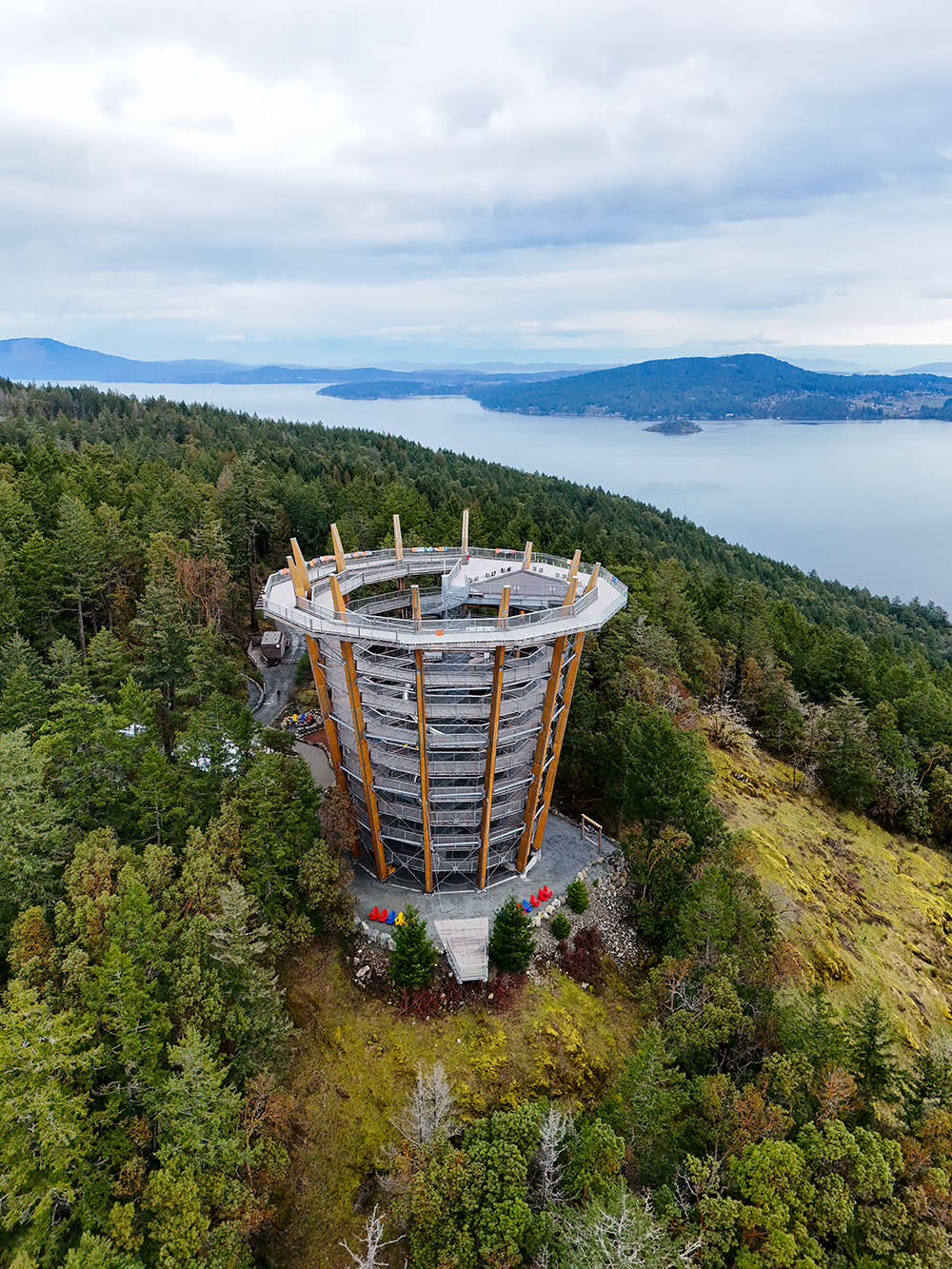 Drone shot of the Spiral Tower in the background of the Saachet Inlet and surrounding landscapes at the Malahat Skywalk