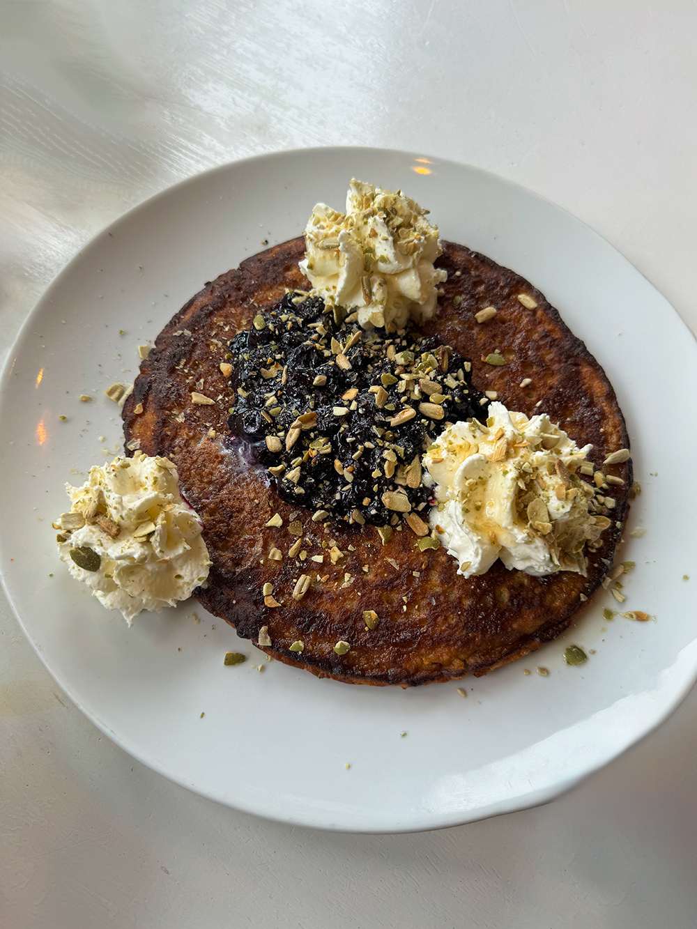 Sleeping Beauty Pancakes (oatmeal gluten free pancakes, blueberries, whipped cream, maple syrup, pumpkin seeds) at the Nourish Kitchen and Cafe, Victoria, BC
